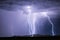 Lightning bolts strike a mountain during a thunderstorm