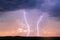 Lightning bolts strike in a thunderstorm at sunset