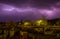 Lightning cracking during thunderstorm over houses of tiny town