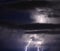 Lightning cuts across the summer sky over a South Florida beach