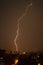 Lightning flashes over the night city. Discharge of electricity in the night sky.