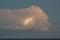 Lightning flashes in a thundercloud above the sea on a summer evening