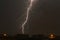 Lightning in a slow moving thunderstorm over trees.