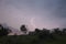 Lightning in a slow moving thunderstorm over trees.