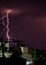 Lightning storm over the city buildings. Lightning bolt strike during a thunderstorm on metropolitan city. Dark sky with bright