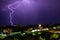 Lightning storm over city in purple light