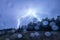 Lightning strike over treetops with rain waterdrops on a lens