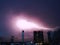 Lightning thunder flash over city in purple light