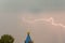 Lightning during a thunderstorm in the sky above the dome and cr