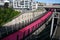 Lightpath over freeway. Urban walkway in pink color for bicycle riders. Nelson Street Cycleway over highway, Auckland, New Zealand