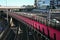 Lightpath over freeway. Urban walkway in pink color for bicycle riders. Nelson Street Cycleway over highway, Auckland, New Zealand