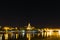 Lights and buildings reflected on the water during nighttime in Cadiz, Spain