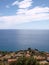 Liguria coastal village houses seascape on bright day.