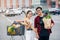 Likable asian couple hold paper eco bags with organic healthy food in hands while standing near store mall. Happy family