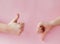 Like hand sign on a light trending pink background, Successful concept, female hand thumb up