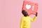 Like. Happy black man holding like heart icon pinata on pink