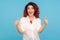 Like! Portrait of enthusiastic vivid hipster woman with fancy red hair in white shirt showing thumbs up and smiling