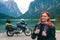 Like it. Portrait of female motobiker in protective turtle jacket. Touring motorcycle background. Extreme vacation, motorcyclist