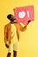 Like. Smiling black man with like icon, heart pinata on yellow