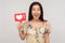 Like social media content! Delighted enthusiastic girl in blouse showing internet heart icon, recommending to subscribe