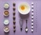 Lilac background food knolling walnut greek seeds sunflower sugar cube refined corn spoon egg round bowl cake mold flour blue pink