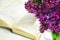 Lilac and a book. A bouquet of spring flowers against the background of an open book lying