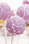 Lilac cake pops lavishly decorated with icing.