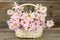 Lilac chrysanthemums in basket on grey wooden background.