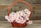 Lilac chrysanthemums in basket on grey wooden background.