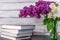 Lilac flowers and books on wooden background. cover, card. copy space.