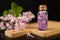 Lilac flowers and essential oil in a glass vessel. Ecological preparations on a wooden board