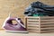 Lilac iron and a stack of clothes in a box on a natural wooden background. ironing clothes. household electrical appliances