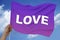 Lilac multi-colored flag on a luxurious texture of satin, silk with waves, close-up, copy space, the word LOVE