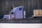 Lilac semi truck and concrete wall fence road