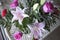 Lilies and and pink roses on bamboo table close up