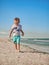 Lilltle boy playing on the seaside in summertimes. Baby having fun with the sand. Summer rest concept. Happy childhood