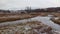 Limanowa, South Poland : Pan shot of 2 rivers joining with ducks beneath overcast against polish mountains in white snow during