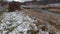 Limanowa, South Poland: Tilted up shot of a waterfall on river beneath overcast against polish mountains in white snow during