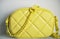 Lime cross body bag. Ladies bright-colored handbag on gray background. Yellow bag