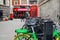 A Lime electric assist rental bike parked with regular bicycles with a Red London Double Decker Bus, a traditional red phone box