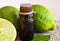 Lime essential oil in a glass bottle and fresh ripe lime fruits.Lime oil for spa,aromatherapy and bodycare.