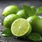 Lime. Fresh lime with water drops on dark background. Green lime with leaves on dark background