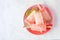 Lime and grapefruit popsicles on a plate, top view over marble