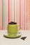 Lime green coffee cup and saucer filled with fresh coffee beans