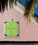 Lime green shutters accent Caribbean pink building in Nassau, Bahamas