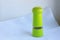 Limegreen peppermill. Kitchen equipment for grinding spices on a linen background. Front view
