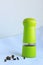 Limegreen peppermill. Kitchen equipment for grinding spices on a linen background. Front view