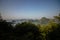 Limestone islands topped by trees under a misty sky in Ha Long Bay, Vietnam