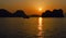 Limestone karsts silhouette and fishing boat at sunset panorama, Halong Bay Vietnam