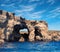 Limestone rock caves and blue Mediterranean water of Comino